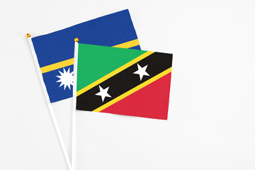 Saint Kitts And Nevis and Nauru stick flags on white background. High quality fabric, miniature...