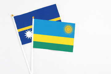 Rwanda and Nauru stick flags on white background. High quality fabric, miniature national flag. Peaceful global concept.White floor for copy space.