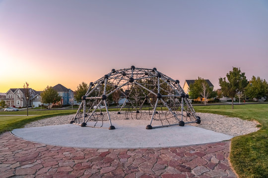 Metal climbing frame in a playground at sunset