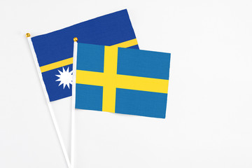 Sweden and Nauru stick flags on white background. High quality fabric, miniature national flag....