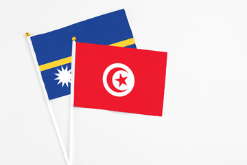 Tunisia and Nauru stick flags on white background. High quality fabric, miniature national flag....