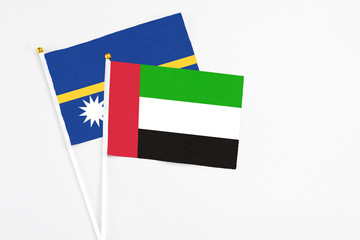 United Arab Emirates and Nauru stick flags on white background. High quality fabric, miniature national flag. Peaceful global concept.White floor for copy space.