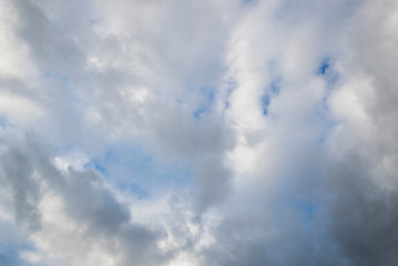 Fast moving clouds during a sunny day in the blue sky with the transition to evening hours along with the occasional flight of the aircraft leaving white traces on a flyby.