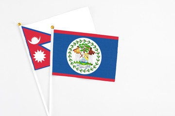 Belize and Nepal stick flags on white background. High quality fabric, miniature national flag. Peaceful global concept.White floor for copy space.