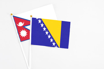 Bosnia Herzegovina and Nepal stick flags on white background. High quality fabric, miniature...
