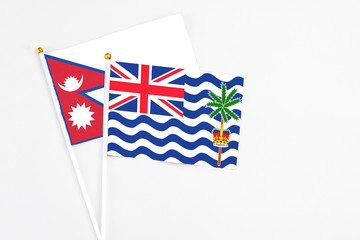 Fototapeta premium British Indian Ocean Territory and Nepal stick flags on white background. High quality fabric, miniature national flag. Peaceful global concept.White floor for copy space.