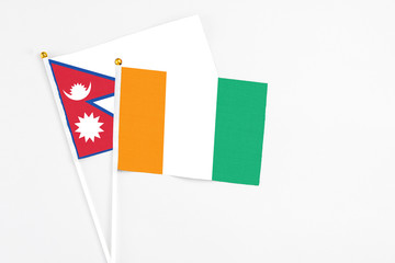 Cote D'Ivoire and Nepal stick flags on white background. High quality fabric, miniature national...