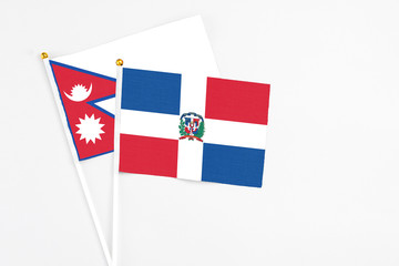 Dominican Republic and Nepal stick flags on white background. High quality fabric, miniature...