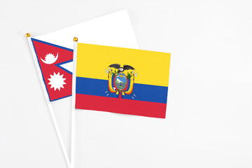 Ecuador and Nepal stick flags on white background. High quality fabric, miniature national flag. Peaceful global concept.White floor for copy space.