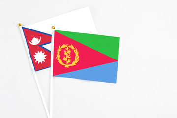 Eritrea and Nepal stick flags on white background. High quality fabric, miniature national flag. Peaceful global concept.White floor for copy space.