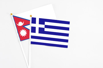 Greece and Nepal stick flags on white background. High quality fabric, miniature national flag. Peaceful global concept.White floor for copy space.