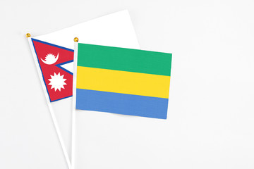 Gabon and Nepal stick flags on white background. High quality fabric, miniature national flag....