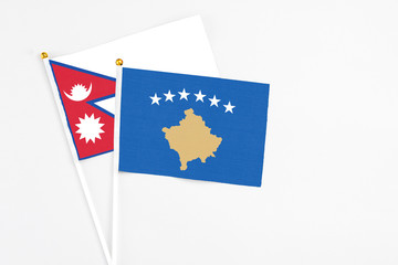 Kosovo and Nepal stick flags on white background. High quality fabric, miniature national flag. Peaceful global concept.White floor for copy space.