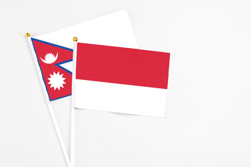 Monaco and Nepal stick flags on white background. High quality fabric, miniature national flag. Peaceful global concept.White floor for copy space.