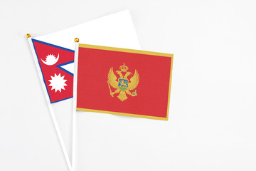 Montenegro and Nepal stick flags on white background. High quality fabric, miniature national flag. Peaceful global concept.White floor for copy space.