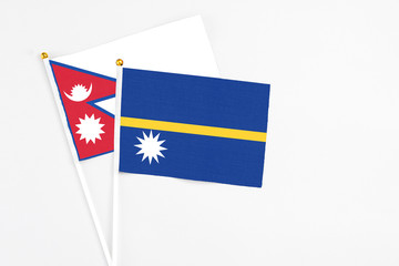 Nauru and Nepal stick flags on white background. High quality fabric, miniature national flag. Peaceful global concept.White floor for copy space.