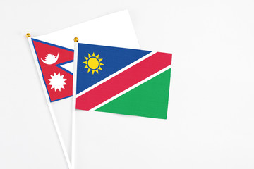 Namibia and Nepal stick flags on white background. High quality fabric, miniature national flag. Peaceful global concept.White floor for copy space.