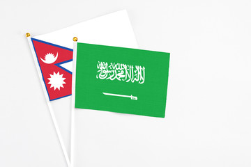 Saudi Arabia and Nepal stick flags on white background. High quality fabric, miniature national flag. Peaceful global concept.White floor for copy space.