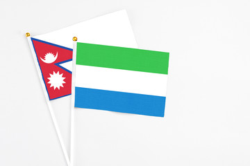 Sierra Leone and Nepal stick flags on white background. High quality fabric, miniature national flag. Peaceful global concept.White floor for copy space.