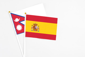 Fototapeta premium Spain and Nepal stick flags on white background. High quality fabric, miniature national flag. Peaceful global concept.White floor for copy space.