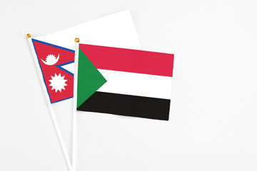 Sudan and Nepal stick flags on white background. High quality fabric, miniature national flag. Peaceful global concept.White floor for copy space.