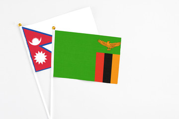 Zambia and Nepal stick flags on white background. High quality fabric, miniature national flag. Peaceful global concept.White floor for copy space.