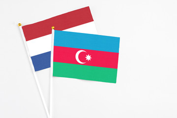 Azerbaijan and Netherlands stick flags on white background. High quality fabric, miniature national flag. Peaceful global concept.White floor for copy space.