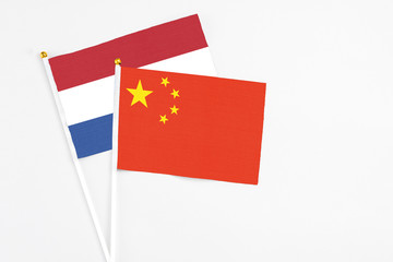 China and Netherlands stick flags on white background. High quality fabric, miniature national flag. Peaceful global concept.White floor for copy space.