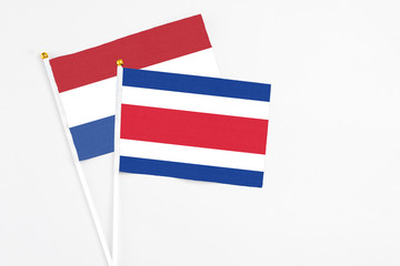 Costa Rica and Netherlands stick flags on white background. High quality fabric, miniature national flag. Peaceful global concept.White floor for copy space.