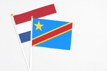 Congo and Netherlands stick flags on white background. High quality fabric, miniature national flag. Peaceful global concept.White floor for copy space.