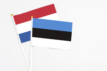 Estonia and Netherlands stick flags on white background. High quality fabric, miniature national flag. Peaceful global concept.White floor for copy space.