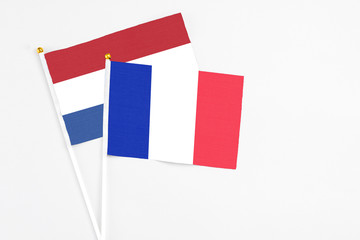 France and Netherlands stick flags on white background. High quality fabric, miniature national flag. Peaceful global concept.White floor for copy space.