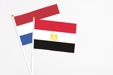 Egypt and Netherlands stick flags on white background. High quality fabric, miniature national flag. Peaceful global concept.White floor for copy space.