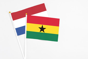 Ghana and Netherlands stick flags on white background. High quality fabric, miniature national flag. Peaceful global concept.White floor for copy space.