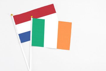Ireland and Netherlands stick flags on white background. High quality fabric, miniature national flag. Peaceful global concept.White floor for copy space.