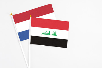 Iraq and Netherlands stick flags on white background. High quality fabric, miniature national flag. Peaceful global concept.White floor for copy space.