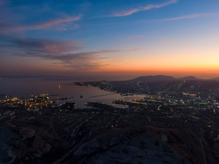 Panoramic photo of the port city at dusk. Port Novorossiysk, Tsemess Bay. Black Sea