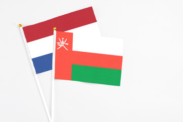 Oman and Netherlands stick flags on white background. High quality fabric, miniature national flag. Peaceful global concept.White floor for copy space.