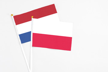 Poland and Netherlands stick flags on white background. High quality fabric, miniature national flag. Peaceful global concept.White floor for copy space.