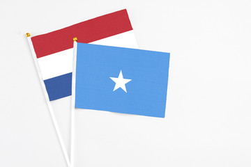Somalia and Netherlands stick flags on white background. High quality fabric, miniature national flag. Peaceful global concept.White floor for copy space.