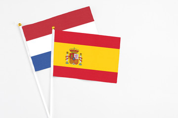 Fototapeta premium Spain and Netherlands stick flags on white background. High quality fabric, miniature national flag. Peaceful global concept.White floor for copy space.