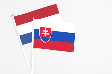 Slovakia and Netherlands stick flags on white background. High quality fabric, miniature national flag. Peaceful global concept.White floor for copy space.