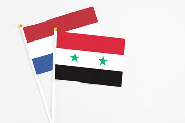 Syria and Netherlands stick flags on white background. High quality fabric, miniature national flag. Peaceful global concept.White floor for copy space.