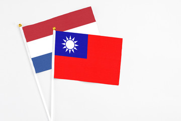 Taiwan and Netherlands stick flags on white background. High quality fabric, miniature national flag. Peaceful global concept.White floor for copy space.