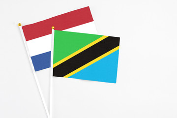 Tanzania and Netherlands stick flags on white background. High quality fabric, miniature national flag. Peaceful global concept.White floor for copy space.