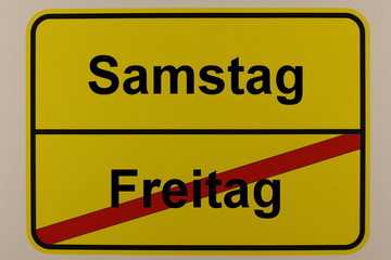 Grafische Darstellung der Wochentage Freitag und Samstag auf einem Ortsschild