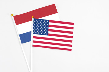 United States and Netherlands stick flags on white background. High quality fabric, miniature national flag. Peaceful global concept.White floor for copy space.