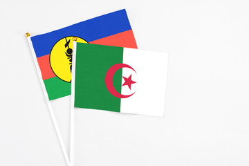 Algeria and New Caledonia stick flags on white background. High quality fabric, miniature national...