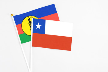 Chile and New Caledonia stick flags on white background. High quality fabric, miniature national flag. Peaceful global concept.White floor for copy space.