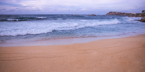 Beach at sunset castle in the distance